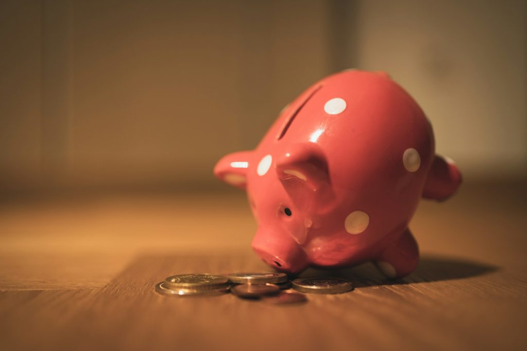 Hucha con monedas representando el ahorro necesario antes de empezar a invertir