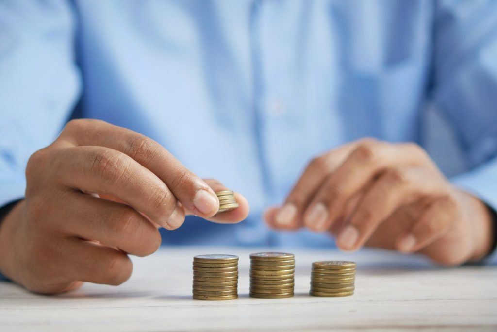 Mano apilando monedas, ahorro conservador con Letras del Tesoro