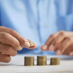 Mano apilando monedas, ahorro conservador con Letras del Tesoro