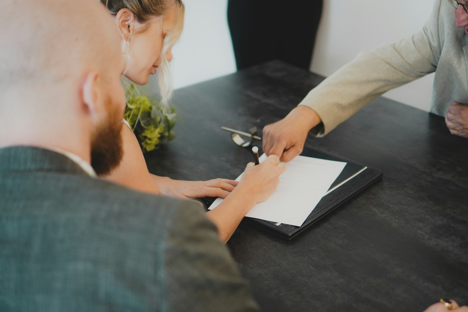 Pareja firmando el contrato de su hipoteca en una mesa, simbolizando a quienes firmaron una hipoteca fija a un tipo de interés bajo hace unos años