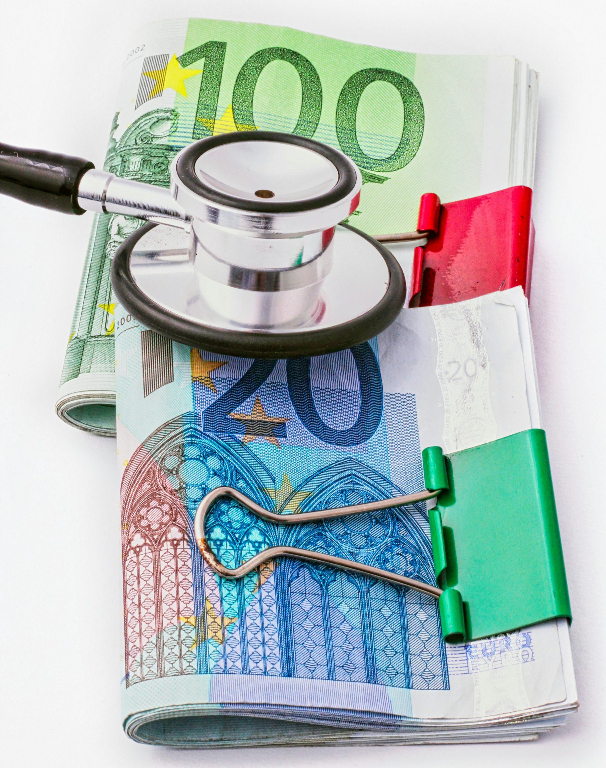 Estetoscopio sobre billetes de euro, representando el coste económico de una baja laboral